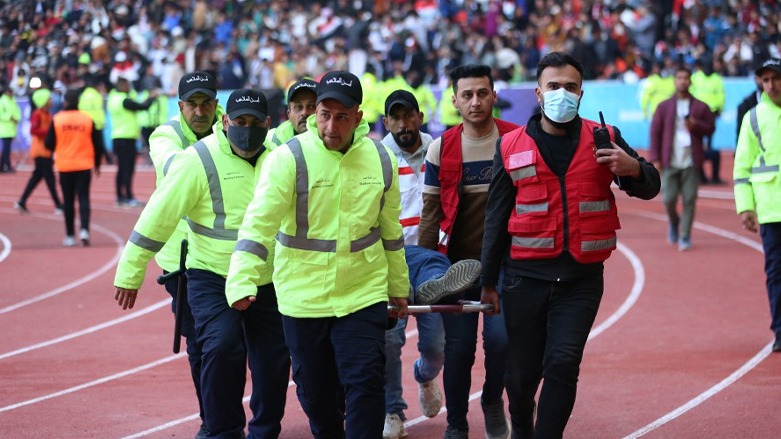 Iraqi stadium security team members carry an injured football fan into an emergency area at the Basra International Stadium following a stampede, Jan. 19, 2023. (Photo: Hussein Faleh/AFP)